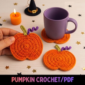 May include: Three orange crochet pumpkin coasters with green stems and purple curly vines. One coaster sits under a purple mug, while another is held. An orange candle and a small black witch hat are nearby. Text reads PUMPKIN CROCHET/PDF.