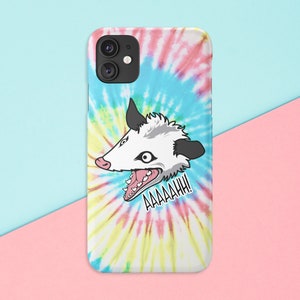 K&ouml;nnte beinhalten: Eine wei&szlig;e und blaue Batik-Handyh&uuml;lle mit einem Cartoon-Bild eines Opossums mit offenem Mund und dem Text "AAAAAHHH!" darauf.