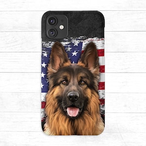 Könnte beinhalten: Eine schwarze Handyhülle mit dem Gesicht eines Deutschen Schäferhundes. Der Hund schaut direkt in die Kamera. Der Hintergrund ist eine verblasste amerikanische Flagge.