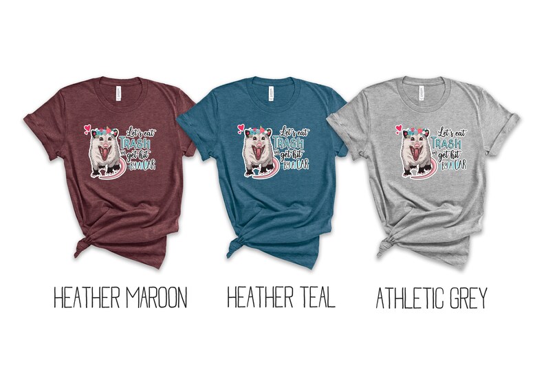 May include: Three t-shirts in heather maroon, heather teal, and athletic grey. Each shirt features a graphic of an opossum wearing a floral crown, with the text "Let's eat trash and get hit by a car."
