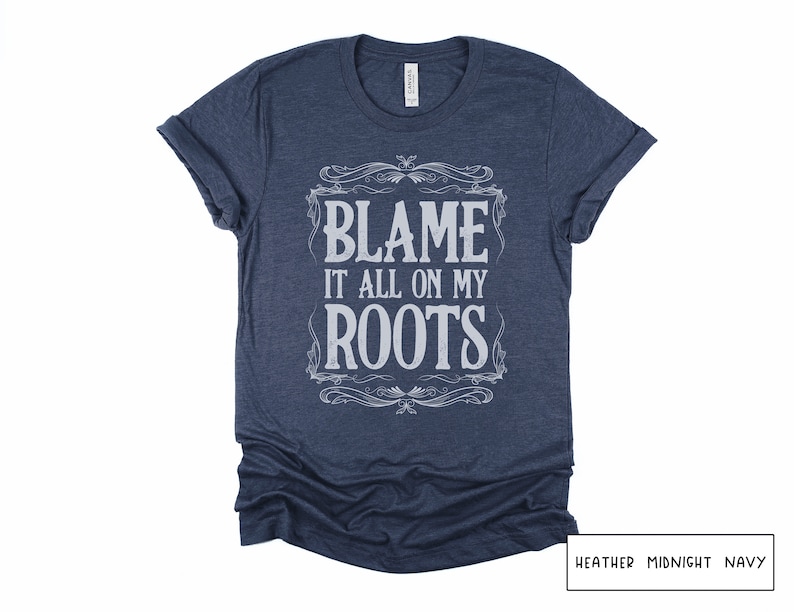 May include: A heather midnight navy t-shirt with the text "Blame it all on my roots" in a vintage-style font.