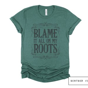 May include: A green heather t-shirt with a vintage-style graphic that says "Blame it all on my roots".