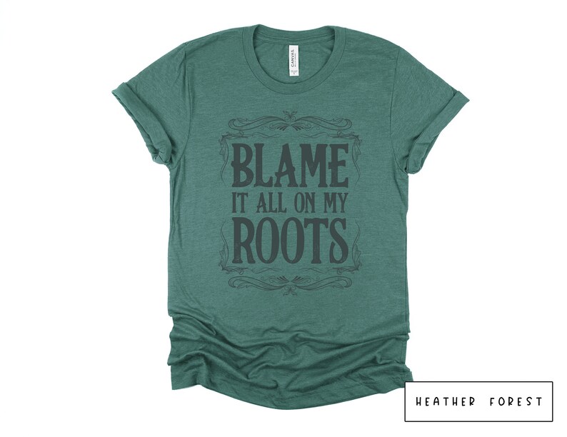 May include: A green heather t-shirt with a vintage-style graphic that says "Blame it all on my roots".