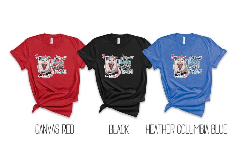 May include: Three t-shirts in red, black, and blue. Each shirt features a graphic of an opossum with a unicorn horn and the text "Let's eat trash and get hit by a car".