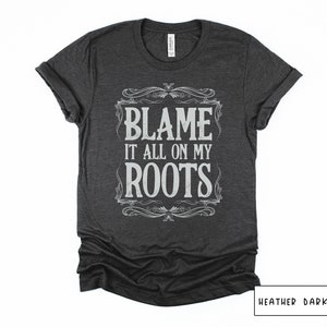 May include: Heather dark gray t-shirt with a vintage-style graphic that says "Blame it all on my roots".