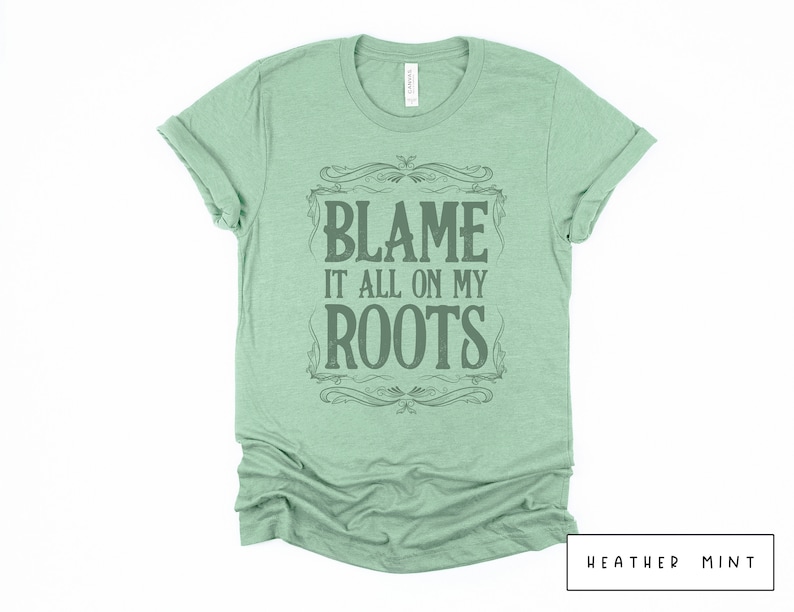 May include: A heather mint green t-shirt with a vintage-style graphic that says "Blame it all on my roots".