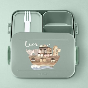 Puede incluir: Una fiambrera verde con tapa extra&iacute;ble y un compartimento separado para cubiertos. La fiambrera tiene una ilustraci&oacute;n colorida de animales en un barco y el nombre "Luca" impreso en la parte delantera. La fiambrera est&aacute; hecha por Mepal.
