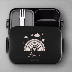 May include: Black lunchbox with a rainbow and clouds design. The lunchbox has a removable fork and a personalized name, "Anna".