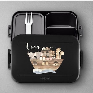 Puede incluir: Lonchera negra con tapa extra&iacute;ble y un tenedor en el interior. La lonchera tiene una ilustraci&oacute;n colorida de animales en un barco con el nombre "Luca" impreso en la parte delantera. La lonchera es de la marca "MEPAL".