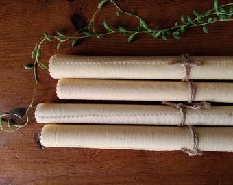 May include: Four rolled up pieces of parchment paper tied with twine. The parchment paper is a light beige color and the twine is a natural brown color.