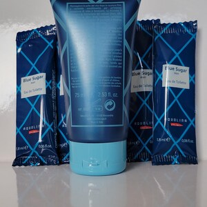 May include: A blue tube of "Blue Sugar" Eau de Toilette, 75 ml, with a light blue cap, and three matching 1.8 ml sample packets. The packaging features a diamond pattern and the brand name "AQUOLINA".
