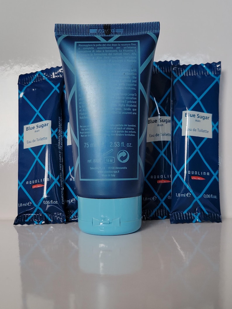 May include: A blue tube of "Blue Sugar" Eau de Toilette, 75 ml, with a light blue cap, and three matching 1.8 ml sample packets. The packaging features a diamond pattern and the brand name "AQUOLINA".