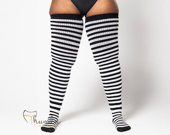 May include: Black and white striped thigh-high socks. The socks feature alternating thick stripes of black and white, extending from the toes to the upper thigh. The socks are made of a soft, stretchy material.