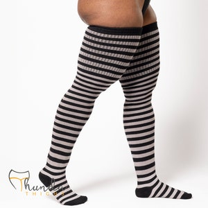 May include: Over-the-knee striped socks in black and gray. The socks feature a horizontal stripe pattern and are designed to reach the upper thigh. The socks have a black cuff and foot, with the brand logo visible.