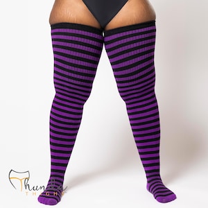 May include: Thigh-high socks with horizontal stripes in black and purple. The socks cover the legs from the feet to the upper thighs. The socks are made of a soft, stretchy material.