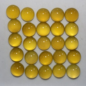 May include: Twenty-five round, yellow cabochon gemstones arranged in a grid pattern. The gemstones have a smooth, polished surface and a translucent appearance, with variations in color from light to deep yellow.