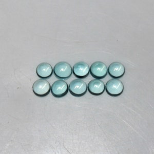 May include: Ten round, light blue cabochon gemstones.