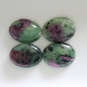 May include: Four oval-shaped green and pink gemstones with a speckled pattern.