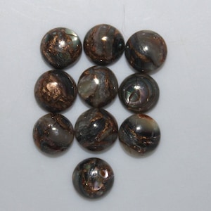 May include: Ten round iridescent abalone shell cabochons with copper flecks. The cabochons are approximately 1 inch in diameter.