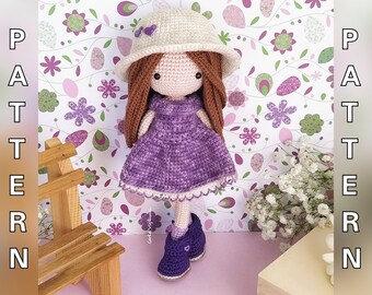 May include: A crocheted doll with brown hair, a purple dress, and a white hat. The doll is standing on a pink surface with a floral pattern.