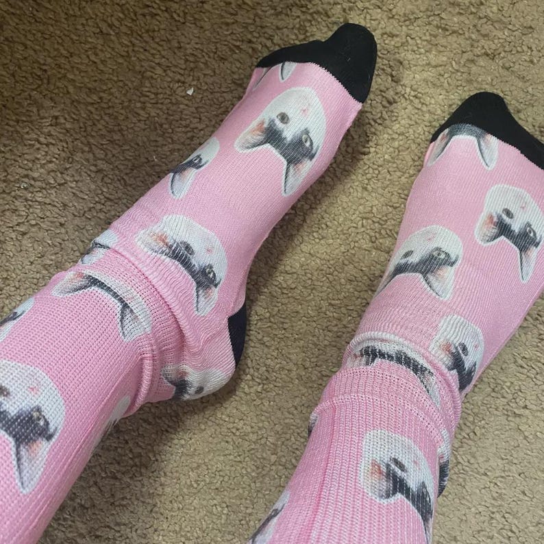 Pink custom pet face socks worn on feet with black toe and heel