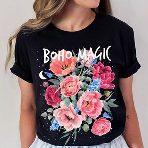 Może przedstawiać: Czarny T-shirt z kwiatowym wzorem i napisem "BOHO MAGIC" w kolorze białym.