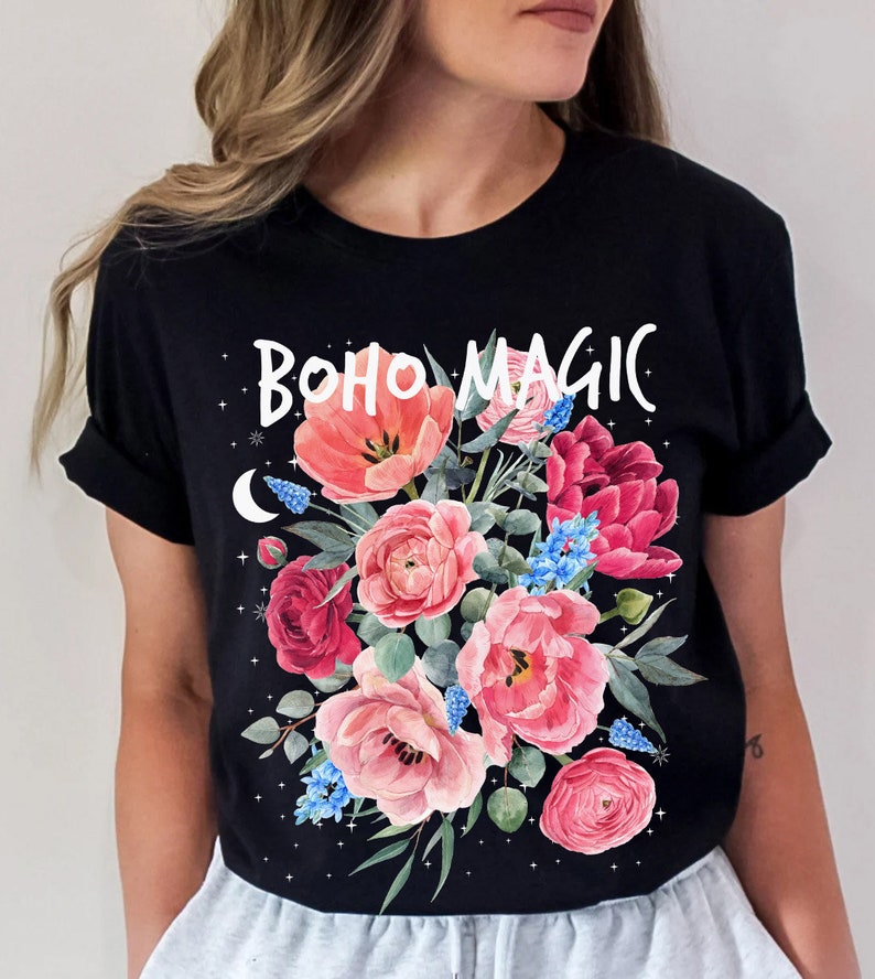 Może przedstawiać: Czarny T-shirt z kwiatowym wzorem i napisem "BOHO MAGIC" w kolorze białym.