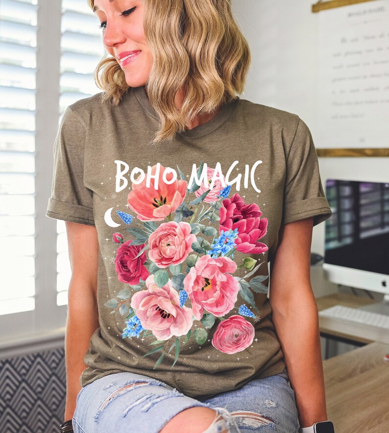 Może przedstawiać: Zielona koszulka z kwiatowym wzorem i napisem "boho magic" białymi literami.