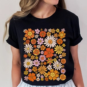 May include: Black t-shirt with a retro floral print featuring orange, yellow, pink, and white flowers.