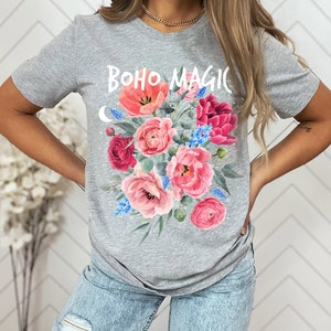 Może przedstawiać: Szara koszulka z nadrukiem kwiatowym i tekstem "BOHO MAGIC" z przodu.