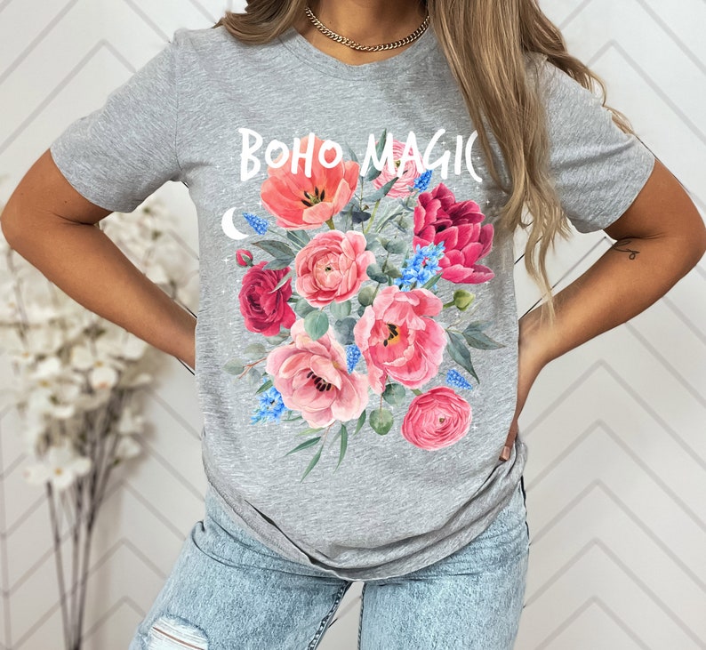 Może przedstawiać: Szara koszulka z nadrukiem kwiatowym i tekstem "BOHO MAGIC" z przodu.