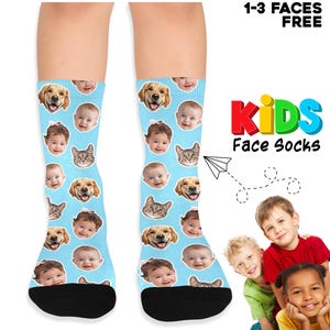 May include: Light blue crew socks featuring a repeating pattern of various human faces, a golden retriever, and a cat. The text 1-3 FACES FREE and KIDS Face Socks is printed on the right side of the image next to a photo of three children.