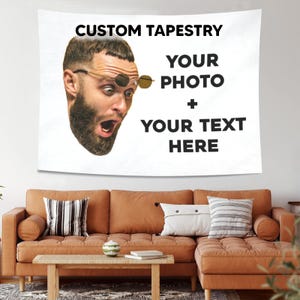 May include: A white rectangular wall tapestry featuring the black text CUSTOM TAPESTRY YOUR PHOTO + YOUR TEXT HERE. To the left, a printed graphic shows a bearded person with wide eyes wearing round sunglasses, mouth open in a surprised expression.