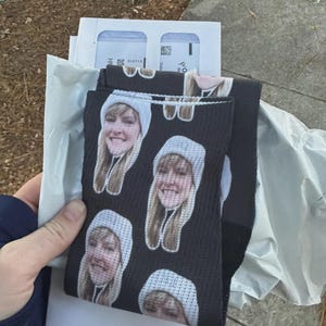 Black custom face socks held in hand with personalized photo print