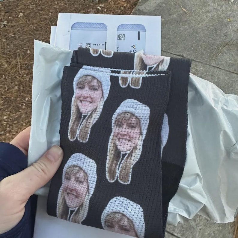 Black custom face socks held in hand with personalized photo print