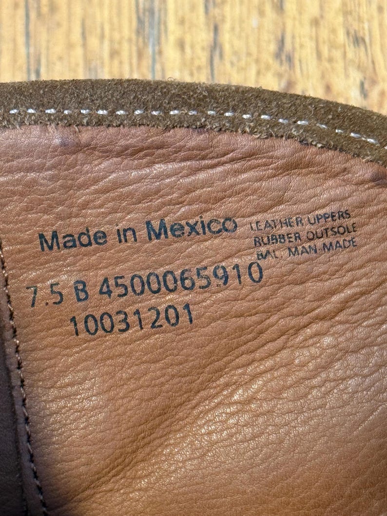 May include: Close-up of the inside of a brown leather boot. The text "Made in Mexico" is visible, along with "7.5 B 4500065910 10031201". The boot has a rubber outsole and leather uppers.
