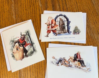 Könnte beinhalten: Drei Weihnachtskarten mit Illustrationen. Eine Karte zeigt eine Teufelsfigur mit einer Person in einem Fass. Eine andere zeigt den Weihnachtsmann und eine Person hinter Gittern. Die dritte Karte zeigt zwei Personen auf einem Schlitten.