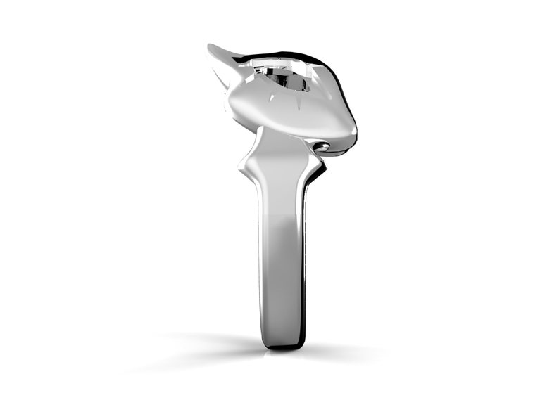 May include: A silver ring with a stylised design featuring a single clear gemstone.