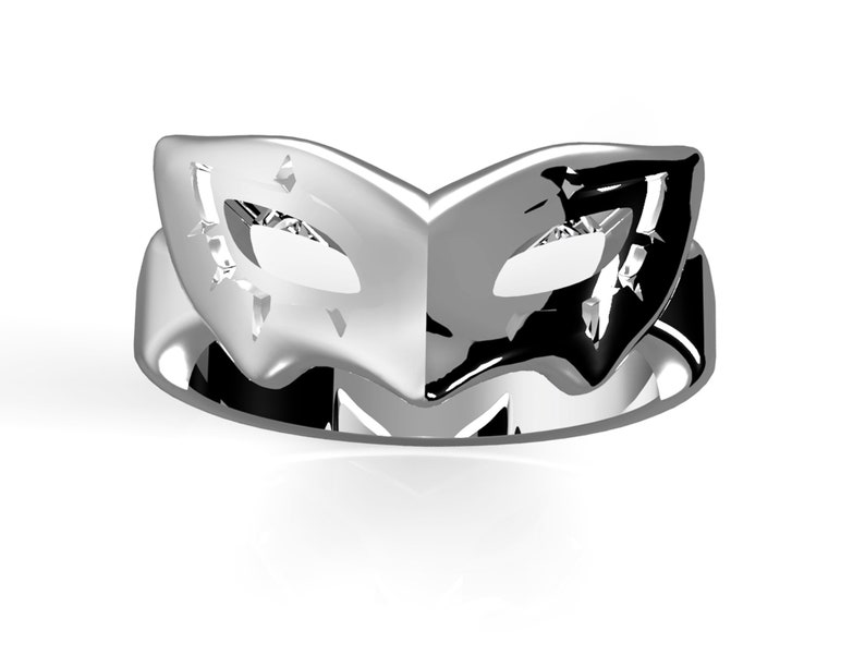 May include: A silver ring featuring a black and white mask design. The mask is a half-mask with a pointed top and a curved bottom. The ring is a simple band with a smooth finish.
