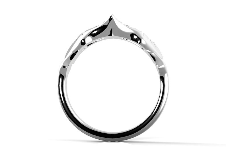 May include: A silver ring with a distinctive, pointed design. The ring is crafted from smooth metal and has a simple, elegant style.