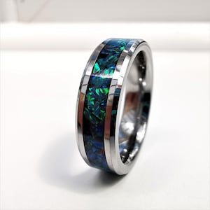 May include: A silver tungsten carbide ring with a green and blue opal inlay.