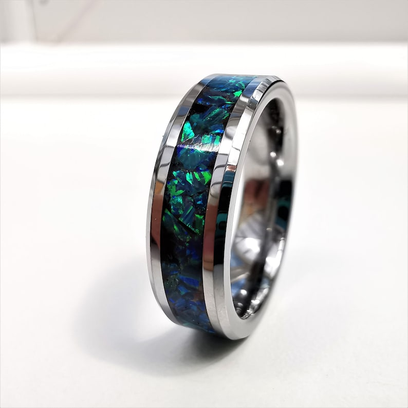 May include: A silver tungsten carbide ring with a green and blue opal inlay.