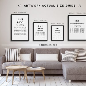 May include: A guide to artwork actual sizes for printing, showing four different ratios: 2x3, 3x4, 4x5, and ISO international size. The guide is displayed on a wall in a living room setting with a gray sectional sofa and two wooden coffee tables.