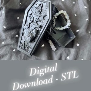 May include: A black coffin-shaped box with intricate carvings of a heart, flowers, and a bird. Inside, a bracelet and a pendant necklace are visible. The text "Digital Download - STL" is displayed at the bottom.