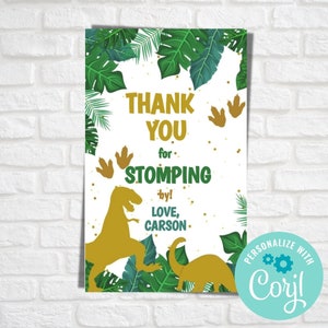 Op de afbeelding: Bedankt voor het langs komen! Een witte kaart met groene en gouden dinosaurus silhouetten, groene bladeren en gouden voetafdrukken. De tekst luidt "Bedankt voor het langs komen! Liefs, Carson."