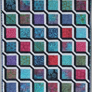 May include: A colorful quilt with a geometric design. The quilt features a repeating pattern of squares in various colors, including pink, blue, purple, and green, framed by black and white lines. The overall design creates a 3D effect.
