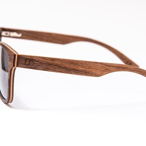 Peut inclure: Une paire de lunettes de soleil en bois brun avec des verres fonc&eacute;s. Les lunettes ont un design simple et classique et sont faites de bois de haute qualit&eacute;.