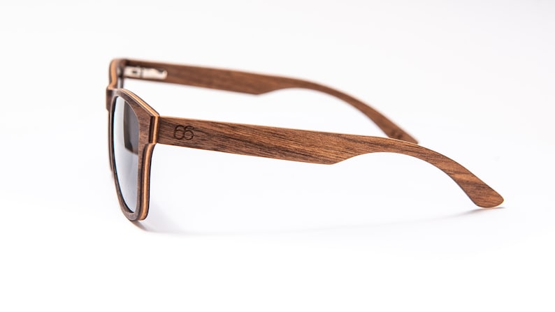 Peut inclure: Une paire de lunettes de soleil en bois brun avec des verres fonc&eacute;s. Les lunettes ont un design simple et classique et sont faites de bois de haute qualit&eacute;.