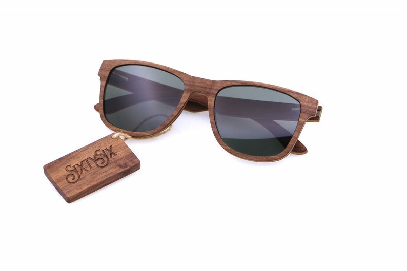 Peut inclure: Lunettes de soleil en bois brun avec des verres gris fonc&eacute; et une &eacute;tiquette en bois qui dit "SIXSIX".