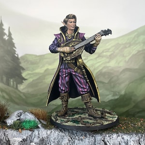 May include: A miniature figure of an elf playing a lute. The elf wears a purple and gold outfit with a long coat. The figure is standing on a circular base with a detailed forest-like design. The background shows a painted landscape.